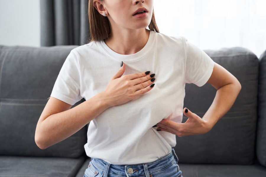 Kobieta dotyka bolącej piersi, może zmagać się z hiperprolaktynemią.