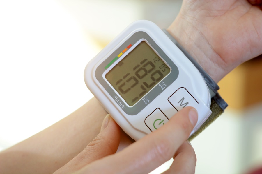 Założony na rękę ciśnieniomierz nadgarstkowy, pokazuje wysokie wartości ciśnienia tętniczego.