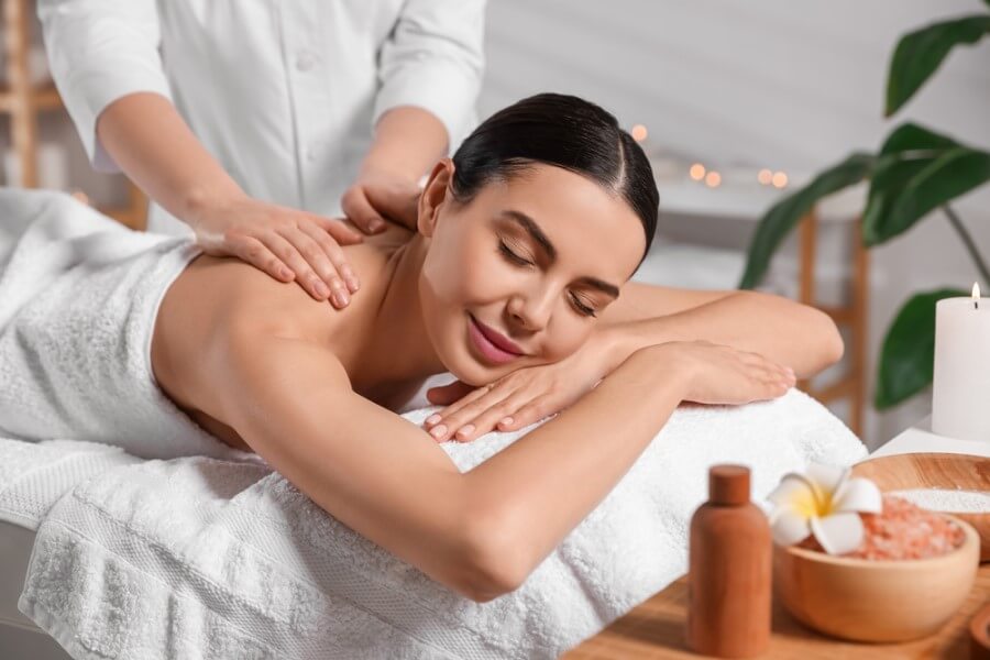 Kobieta poddaje się relaksującemu masażowi.