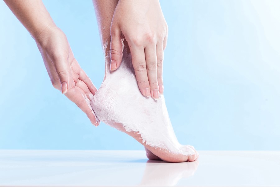 Kobieca stopa podczas intensywnego peelingu na modzele.