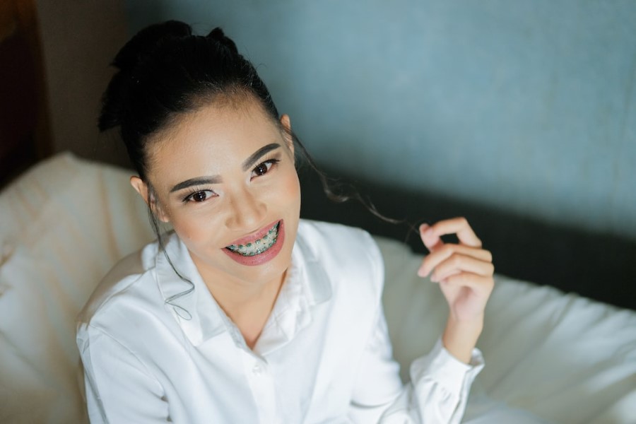 Uśmiechnięta dziewczyna z widocznym na zębach aparatem ortodontycznym.