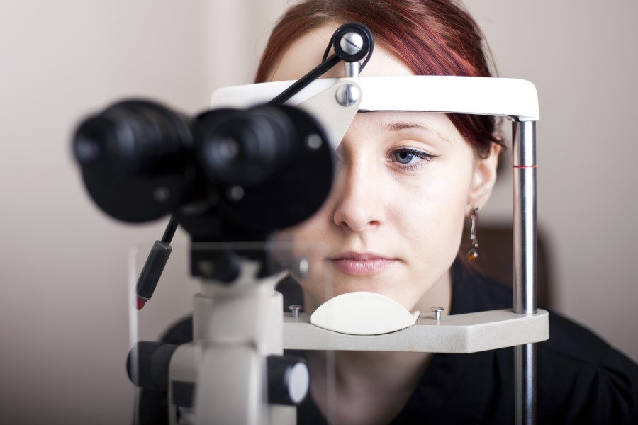 Kobieta w trakcie badania okulistycznego, będącego częścią diagnostyki chorób oczu.