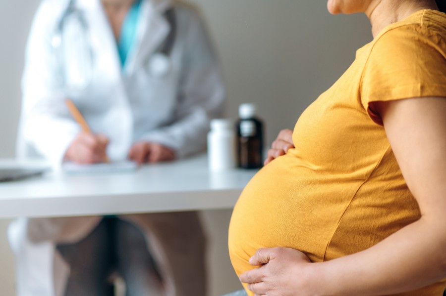 Kobieta w ciąży podczas wizyty lekarskiej u ginekologa.
