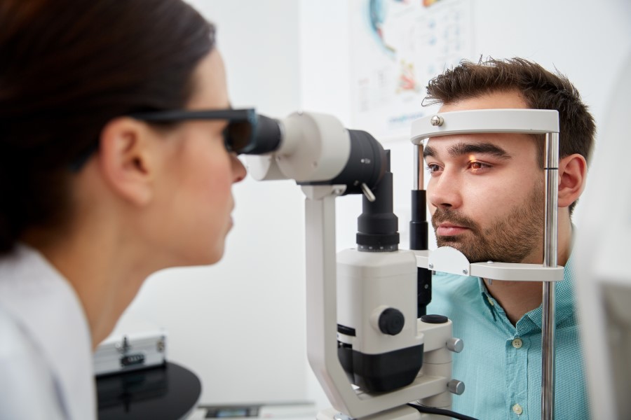 Mężczyzna bada się u okulisty w kierunku diagnostyki nadciśnienia w oku.